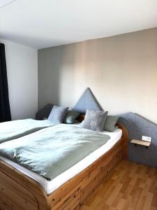 a bedroom with a large bed with a wooden frame at FeWo Bergruh 922 im Ferienpark Oberallgäu in Missen-Wilhams +25 photos