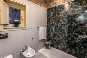 a bathroom with a black and white patterned wall at Vintage Rooms in Palermo +34 photos