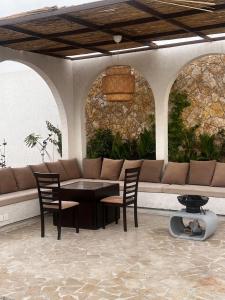 un patio con divano, tavolo e sedie. di Chalet with a modern bohemian design a Riyad