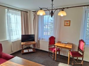 a living room with a table and chairs and a television at Valdštejn in Liberec