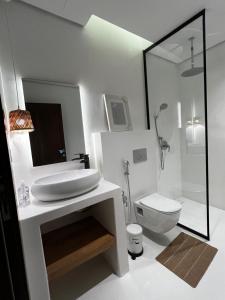 un bagno bianco con lavandino e WC di Chalet with a modern bohemian design a Riyad