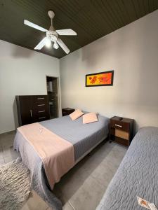 Un dormitorio con dos camas y un ventilador de techo. en Continente Boutique, en San Clemente del Tuyú