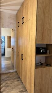 a hallway with wooden cabinets in a house at SHoliday Sky Panoramic Apartment New Building Private Parking in Timişoara +71 photos