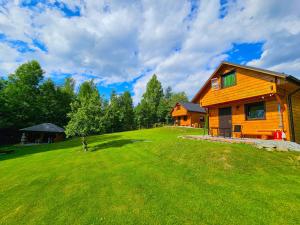 a house on a grassy hill next to a house at Domki Mosorczyk in Zawoja