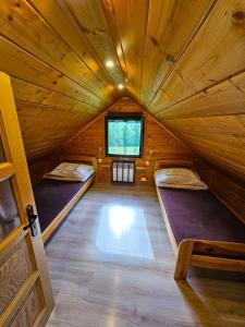 a room with two beds in a wooden cabin at Domki Mosorczyk in Zawoja