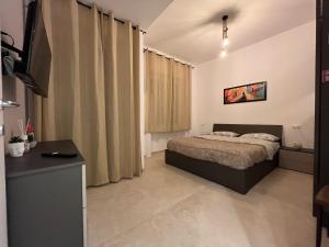 a bedroom with a bed and a television in it at Capitan Ale in Sanremo