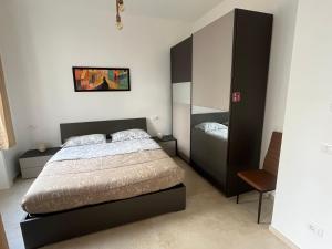 a bedroom with a large bed and a cabinet at Capitan Ale in Sanremo