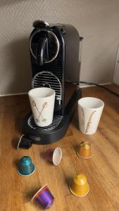 Hyggelig leilighet i sentrum في هيمسيدال: آلة صنع القهوة مع كوبين على طاولة +13 صورة