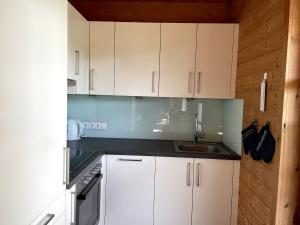 a kitchen with white cabinets and a sink at Charmantes Studio im Seengebiet in Mattsee