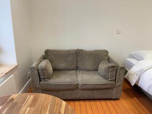 un sofá en una sala de estar junto a una cama en Studio La cabine, en Wimereux