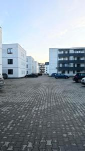um parque de estacionamento com carros estacionados em frente aos edifícios em Vanilla Studio Apartment 2 em Timişoara