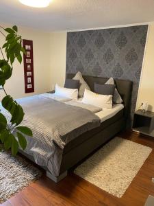 a bedroom with a bed with a gray headboard at Ferienwohnungen Rurseeblick in Einruhr