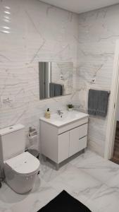 Un baño blanco con inodoro y lavabo. en Casa da Praça, en Murtosa 21 fotos más
