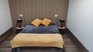 Un dormitorio con una cama con dos almohadas amarillas. en Casa da Praça, en Murtosa
