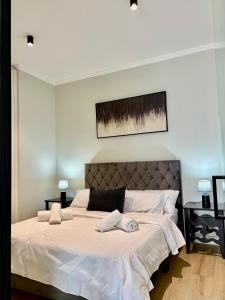 una camera da letto con un letto grande con lenzuola bianche di Stunning Apartment in Ellipse Waterfall Midrand a Midrand