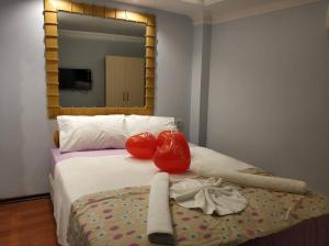 a bed with two boxing gloves and a mirror at Gvar Hotel ANTALYA in Antalya