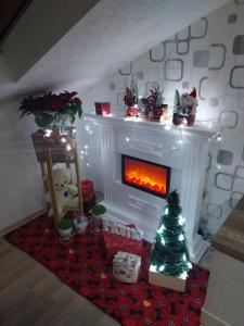 een kerstwoonkamer met een open haard en een kerstboom bij Park Apartment in Kočani