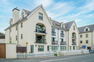 un edificio de apartamentos con una valla blanca en 13 St Brides Bay View - 4 Bedroom - Broad Haven, en Broad Haven