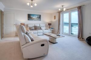 Una sala de estar con un sofá blanco y una mesa. en 13 St Brides Bay View - 4 Bedroom - Broad Haven, en Broad Haven