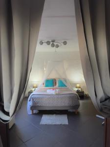 a bedroom with a bed with curtains in it at TI KAZ PIROGUE in L'Étang-Salé les Bains +15 photos