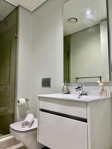 un bagno con lavandino, WC e specchio di Stunning Apartment in Ellipse Waterfall Midrand a Midrand