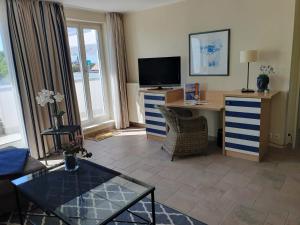 un soggiorno con TV e scrivania con computer di Am Zingster Strand a Zingst