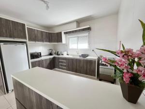 a kitchen with wooden cabinets and a white counter top at Residencial Lazzari Apto 302 in Arroio do Sal +10 photos