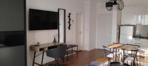 a kitchen with a table and chairs and a television on a wall at Planet-A1012 in Niš