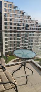 a table and chairs on a balcony with a large building at Planet-A1012 in Niš
