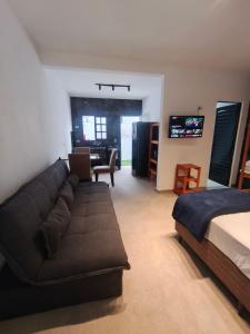 a living room with a couch and a bed at Suites Angra Sol e Mar in Angra dos Reis