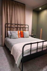 a bedroom with a bed with orange and white pillows at VASIADIS apartment in Síndos