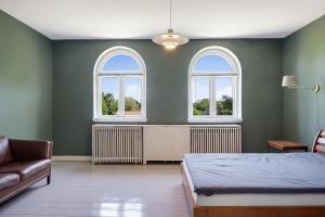 una camera da letto con un letto e due finestre di Historic Residence with Lake View a Stenstrup Altre 16 foto