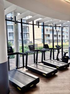 una fila di tapis roulant in una palestra con ampie finestre di Stunning Apartment in Ellipse Waterfall Midrand a Midrand Altre 27 foto