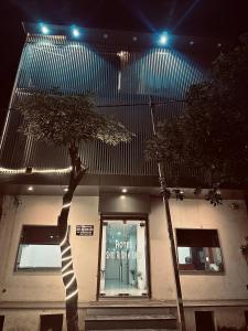 een boom voor een gebouw met verlichting bij Hotel Shri Radha Sneh 500 Mtrs From Shri Krishna Janma Bhumi Mathura in Mathura