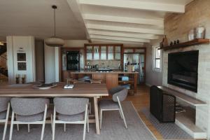a living room with a large wooden table and chairs at Dune Rose Yzerfontein Villa in Yzerfontein