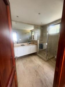 Un baño con ducha y un gran espejo. en Penthouse con vistas espectaculares del Lago de Atitlán, en Panajachel