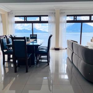 Un comedor con mesa y sillas y una gran ventana. en Penthouse con vistas espectaculares del Lago de Atitlán, en Panajachel