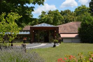 una casa con un pabellón en un jardín en Hotel La Sapinière, en Brioude