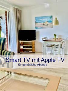 ein Wohnzimmer mit Fernseher und Tisch in der Unterkunft Heimathafen Dieksee in Malente