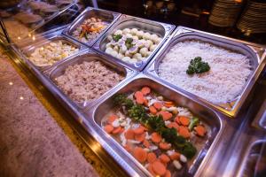 ein Buffet mit Reis und Gemüse in Tabletts in der Unterkunft Casino & Hotel Royal in Česká Kubice