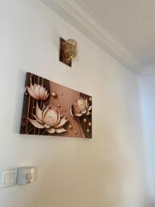 a room with two paintings of flowers on the wall at EdenRose Guest House in Kwabenya