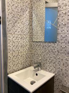 a bathroom with a sink and a mirror at EdenRose Guest House in Kwabenya