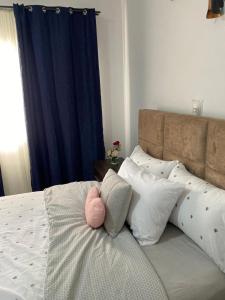 a bed with a pink stuffed animal sitting on it at EdenRose Guest House in Kwabenya