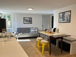 un soggiorno con tavolo e 2 sgabelli gialli di Mia Piccola Casina ad Arcevia