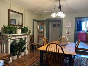 een eetkamer met een houten tafel en stoelen bij The Allen House in North Adams
