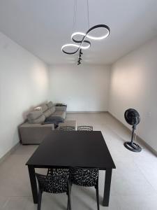 a living room with a black table and chairs at Casa aconchegante com 02 quartos climatizados in Nova Mutum