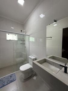 a bathroom with a toilet and a shower and a sink at Casa aconchegante com 02 quartos climatizados in Nova Mutum
