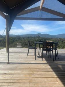 a table and chairs on a deck with a view at Askop Tented Escape & Adventure in The Crags +19 photos