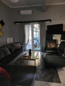 a living room with a couch and a table and a fireplace at jim villa in Andravída