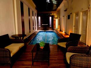 a swimming pool with couches and a table in a room at Hotel Begrand in Tapachula +20 photos